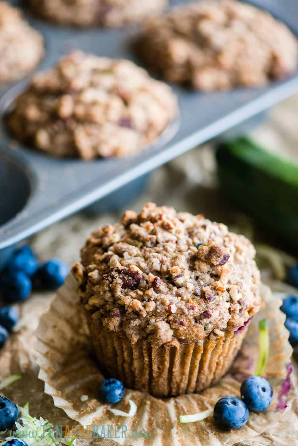 Zucchini Blueberry Muffins with Stresel Topping in wrapper with fresh blueberries