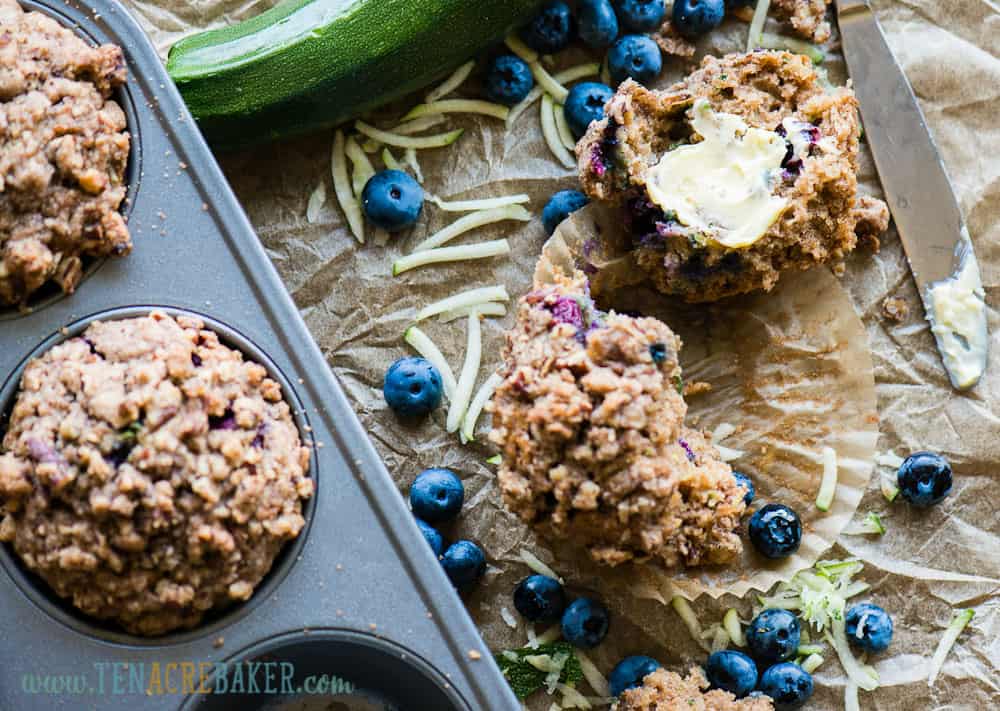 Top of Zucchini Blueberry Muffins with Stresel Topping split open with butter